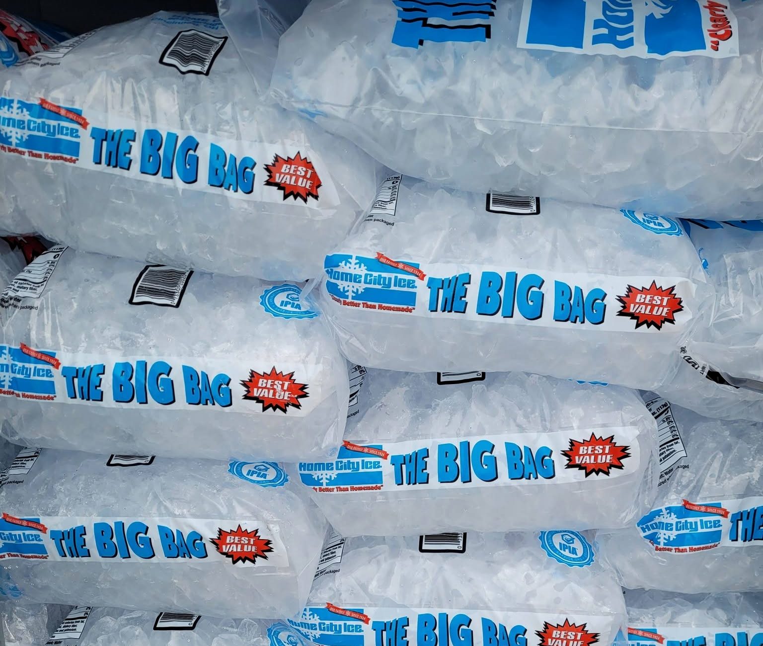 Bags of cubed ice stacked several rows deep inside the ice chest.