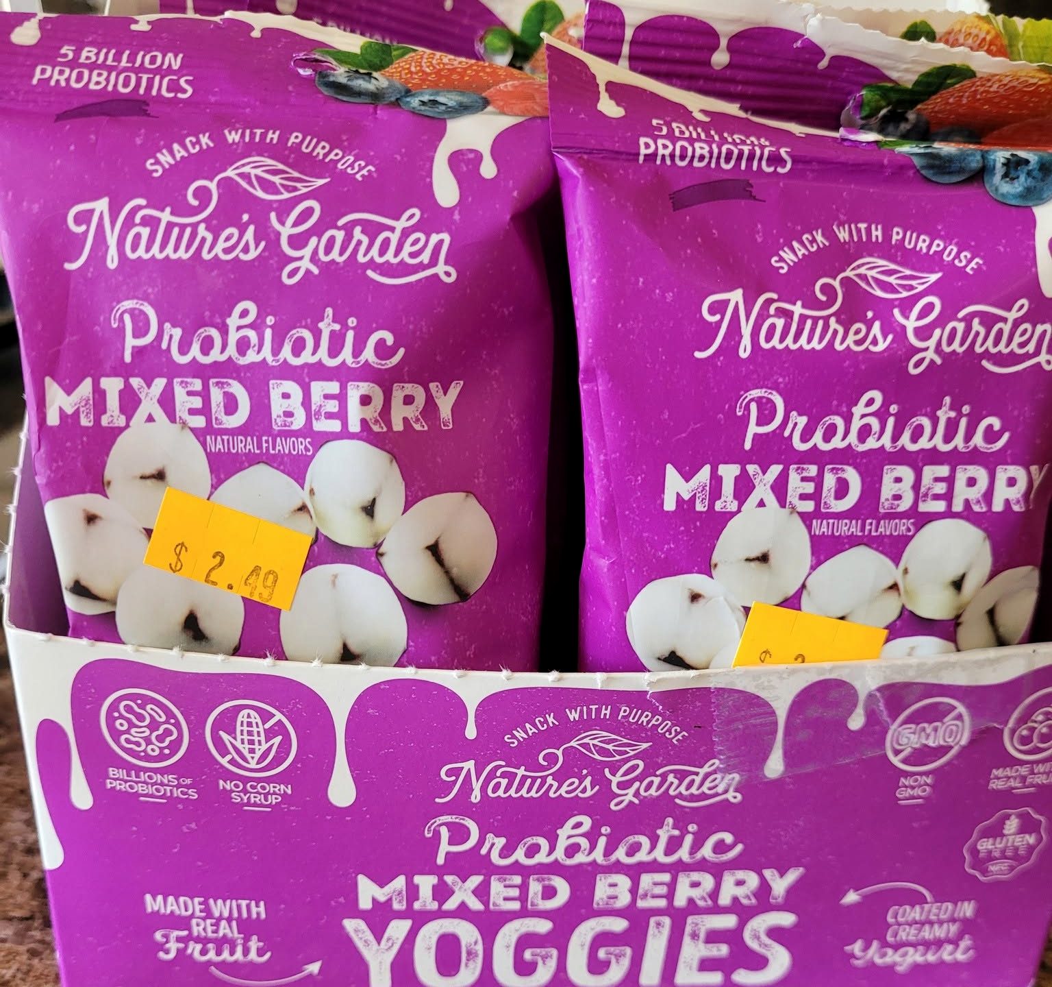 Two bags of yogurt coated fruit snacks standing in their cardboard shipper, with a yellow price sticker written on by hand.